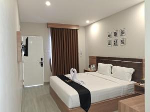 a bedroom with a bed with a towel on it at Nio Garden Hotel in Sumbawa Besar