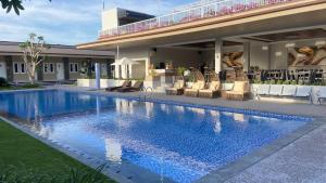 a swimming pool with lounge chairs next to a building at Nio Garden Hotel in Sumbawa Besar