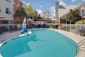 a large blue swimming pool with chairs and a fountain at Residence Inn Dallas DFW Airport North/Irving in Irving