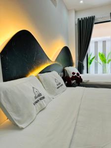 a bed with two pillows on top of it at Vinh Home Apartment in Quang Tri