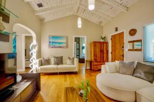 a living room with two white couches and a tv at Entire private Beautiful 2 Bedroom plus Den House with gated front&back yard and Free parking 10min drive to Miami Beach in Miami