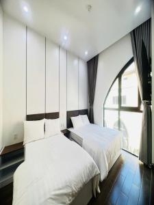 une chambre avec deux lits et une grande fenêtre dans l'établissement VILLA 16 phòng ngủ - SONASEA - VÂN ĐỒN - sát biển - đầy đủ tiện nghi, à Thâm Câu