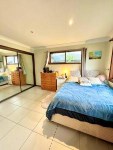a bedroom with a blue bed and a window at Waterfront Wyuna in Tweed Heads