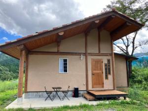 a small house with a porch and a picnic table at Guesthouse EL CAMPO in Gokase