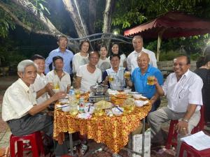a group of people sitting around a table with drinks at Sơn Hiển Homestay in Cam Lâm