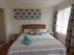 um quarto com uma cama grande com travesseiros azuis em Hibiscus Hideaway em Karikari Peninsula mais 22 fotografias