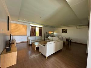 a living room with white couches and a tv at PUNTA CLARK HOTEL in Clark