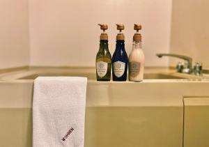 three bottles of wine sitting on top of a sink at Hotel Wohnen in Hakuba