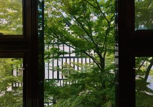 a window view of a building through the trees at Hotel Wohnen in Hakuba