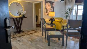 a living room with a yellow couch and chairs at Oceanfront Oasis - Steps to Dolmen Mall in Karachi