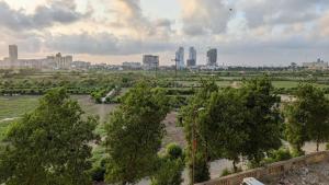 an aerial view of a park with trees and a city at Oceanfront Oasis - Steps to Dolmen Mall in Karachi