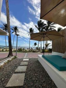 a bench with an umbrella next to the beach at Two Bedroom Affordable Beach Front House in Boracay