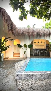a house with a swimming pool in front of it at BIG WAVES BOUTIQUE HOTEL SIARGAO in General Luna
