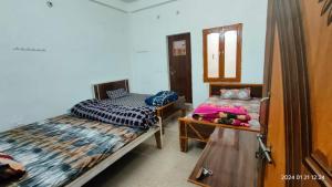 a bedroom with two beds and a dresser in it at Gopal Sadan-2 in Vrindāvan