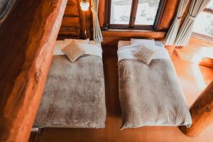 due letti in una stanza con finestra di Hakuba Brownie Cottages a Hakuba