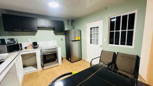 a kitchen with a refrigerator and a table with chairs at Muy cerca de playas y miradores muy accesible a la ciudad y comercios in La Unión