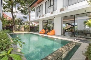 an image of a swimming pool in front of a house at Villa Daun 3 Canggu by Premier Hospitality Asia in Dalung