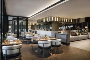 a restaurant with tables and chairs and a bar at Crowne Plaza Bangkok Lumpini Park by IHG in Bangkok