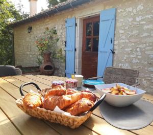 a table with a basket of bread and a bowl of fruit at Chez Berger, ruime 2 persoonskamer met kingsize bed in Flaugnac