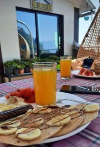 a table with a plate of food and a glass of orange juice at Paul's stay in Darjeeling