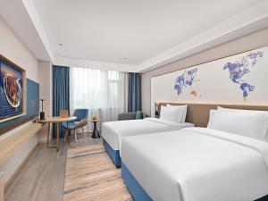 Tempat tidur dalam kamar di Kyriad Hotel Shijiazhuang Railway Station
