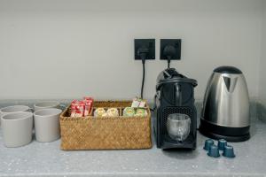 a kitchen counter with a coffee maker and a toaster at Layali Properties - Boho Oasis 3BR Apt - Convention and Exhibition Center in Riyadh +23 photos