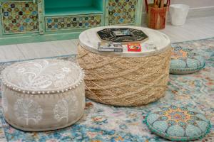 a table and two stools sitting on a rug at Layali Properties - Boho Oasis 3BR Apt - Convention and Exhibition Center in Riyadh