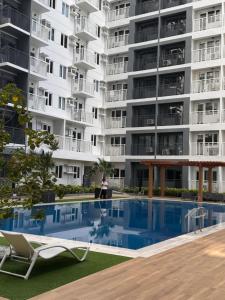 a woman stands in front of a large apartment building at Style 823 Condo - Style Residences SM City Iloilo in Iloilo City