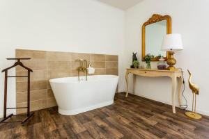 a bathroom with a tub and a table and a mirror at Domaine de Bouhémy in Solférino +43 photos