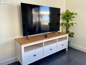 a television on a white dresser in a room at La casa de la playa in Piles
