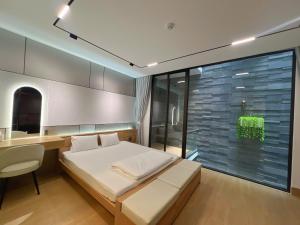 ein Schlafzimmer mit Bett, Schreibtisch und Fenster in der Unterkunft C&M Hotel in Phan Rang