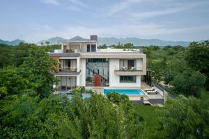 ein Haus mit einem Swimmingpool davor in der Unterkunft amã Stays & Trails Nilaya Amaltaas Villa, Udaipur in Udaipur