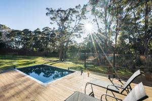 a backyard with a swimming pool and a wooden deck at Highstead House in Daylesford