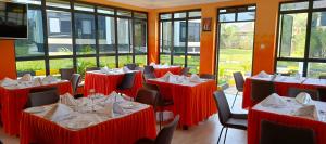 a restaurant with red tables and chairs and windows at Key Villa in Homa Bay