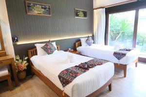 清迈Vimarn Kaew Village and Resort的有窗户的房间里有两张床 更多37张照片
