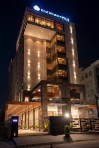 MohaliBest Western Plus Chandigarh Mohali的晚上，建筑物顶部有标志