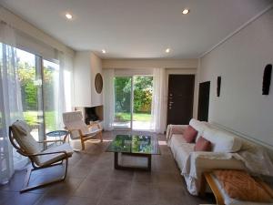 a living room with a couch and a table at Garden house by the sea in Vari