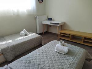 a hotel room with two beds and a desk and a desk at Garden house by the sea in Vari
