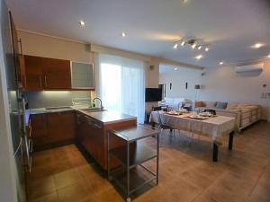 a kitchen and living room with a table and a couch at Garden house by the sea in Vari