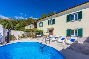 a swimming pool with chairs and a house at Rural House Anka in Drivenik