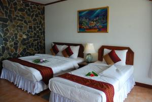 una habitación de hotel con 2 camas en una habitación en Phangan Sunset Resort, en Baan Tai