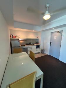 a kitchen with a white table and chairs in a room at Pandanas 15th floor (Water, City & Sunset views) in Darwin