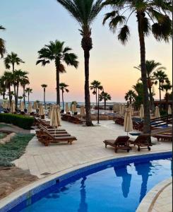 アヤナパにあるAdams Beach Hotel & Spaのヤシの木と海を望むスイミングプール +37枚の写真