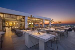 a restaurant with tables and chairs in a building at Adams Beach Hotel & Spa in Ayia Napa