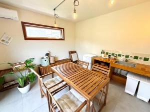 a kitchen with a wooden table and a sink at TAITO BEACH HOUSE in Ichigaya