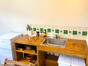 a kitchen counter with a sink and a refrigerator at TAITO BEACH HOUSE in Ichigaya