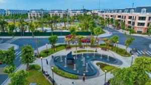a park with a fountain and trees and buildings at Vinh Home Apartment in Quang Tri