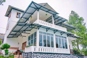 a house with a large window at Villa Putih Alvaro in Gununggeulis