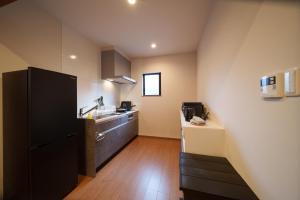 a kitchen with a black refrigerator and a sink at 三和泉 in Beppu