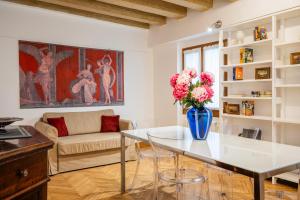 ヴェネツィアにあるParuta Corte Nascosta Apartmentのリビングルーム(テーブル上に花瓶付)